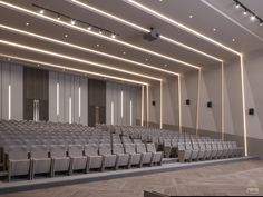 an empty auditorium with rows of gray chairs