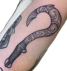 a black and white photo of a tattoo with a knife on it's arm