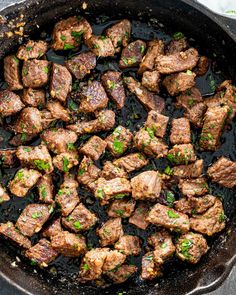 steak in a skillet with green onions and parsley on the side, ready to be cooked