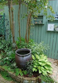 a potted planter sitting in the middle of a garden next to a fence