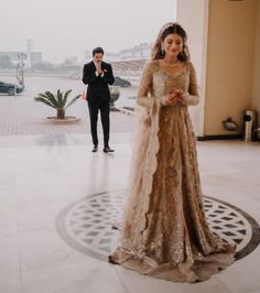 a man and woman in formal wear standing next to each other on a tile floor