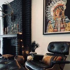 a living room with black leather chairs and a fire place in the corner next to a fireplace