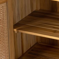 the inside of a sauna with wooden shelves and wicker flooring on it