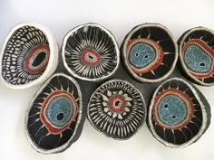 six bowls with designs on them sitting next to each other in front of a white wall