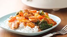 a plate with rice, broccoli and chicken on it next to a fork