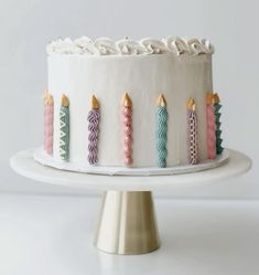 a white cake topped with lots of colorful candles