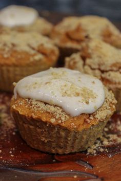 some food that is sitting on a wooden table and has icing on top of it