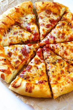 a sliced pizza sitting on top of a wooden cutting board