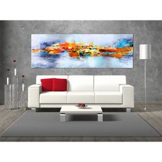 a living room with a couch, coffee table and large painting on the wall above it