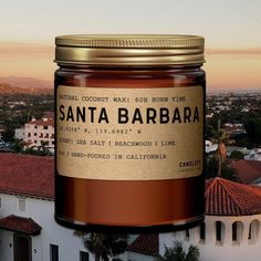 a jar of santa barbara sits on top of a building with the city in the background