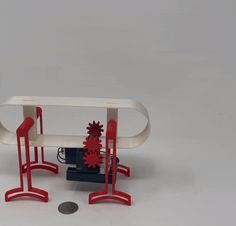 a red and white table with two chairs next to each other on top of a coin