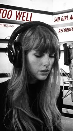 a woman with headphones on in front of a microphone