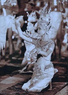 an old photo of a woman dressed in traditional thai garb and holding a fan