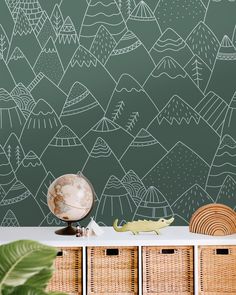 a green wall with white mountains painted on it and wicker baskets in the foreground