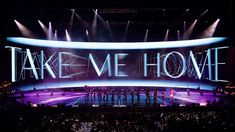 a group of people standing on top of a stage with the words take me home