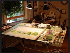 a table with art supplies on it in front of a window