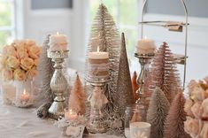 a table topped with candles and christmas trees