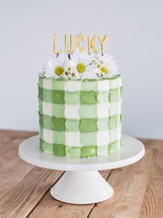 a green and white cake sitting on top of a table next to a wooden sign