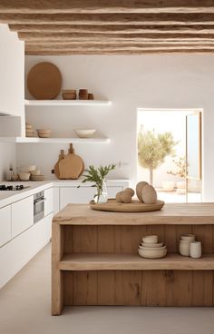 a kitchen with white walls and wooden shelves filled with dishes on top of counter tops