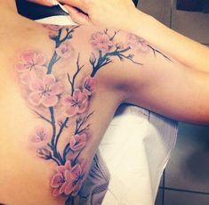 a woman's back with pink flowers on it