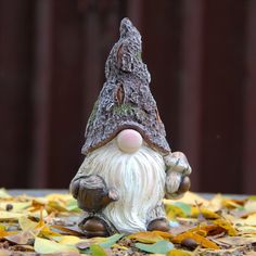 a small gnome figurine sitting on top of leaves