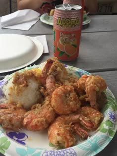 shrimp and rice on a plate with a can of orange juice in the back ground