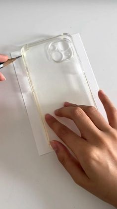 someone is cutting out the back side of a clear case