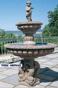 a stone fountain with a statue on top