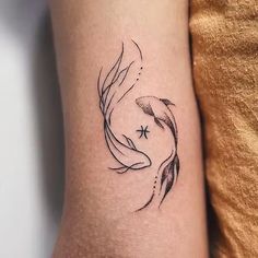 a black and white photo of a goldfish tattoo on the right arm with stars