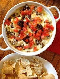 two bowls of food on a table with chips and salsa in the bowl next to them