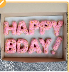 pink donuts with sprinkles in a box that says happy birthday on them