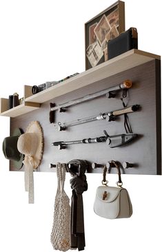 a wall mounted shelf with hooks, hats and purses hanging from it's sides