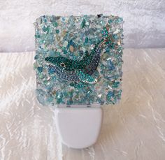 this is a glass mosaic with a bird on it