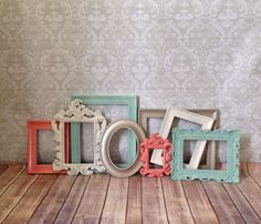 four different colored frames sitting next to each other on a wooden floor in front of a wall