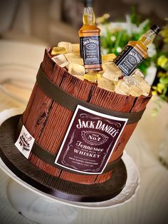 two bottles of jack daniels whiskey in a wooden barrel with ice cubes on the side