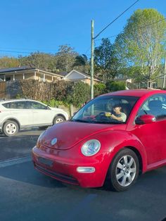 a small red car parked in a parking lot