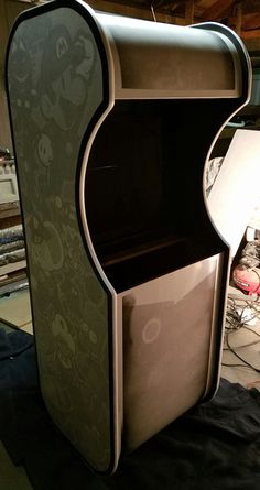 an odd shaped cabinet sitting on top of a black cloth covered floor in a room