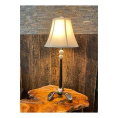 a lamp that is sitting on top of a wooden table next to a wall with wood planks