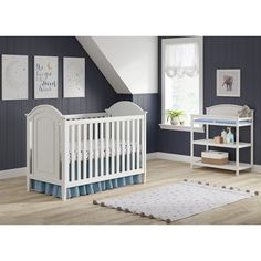 a baby's room with blue walls and white furniture