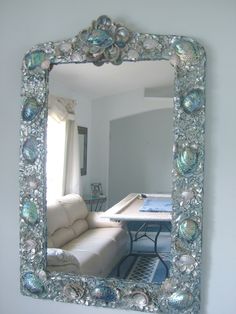 a mirror that is on the wall in front of a couch and table with chairs