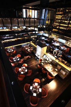 an overhead view of a restaurant with tables and chairs in the foreground, lights on