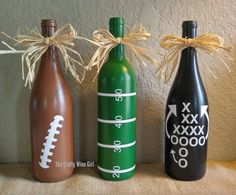 three wine bottles decorated with footballs and numbers