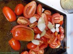 tomatoes and onions on a baking sheet ready to be cooked