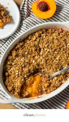 a dish filled with granola on top of a table next to sliced peaches