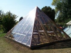 a large greenhouse in the middle of a yard with lots of dirt and grass around it