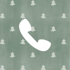 a white phone sitting on top of a green background with christmas trees in the background