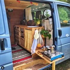 the back end of a blue van with an open door and storage area in it