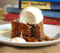 a piece of cake with ice cream on top is sitting on a plate next to some books