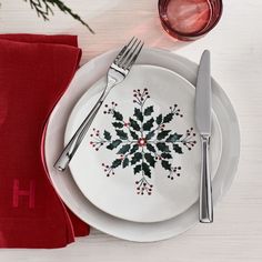 a white plate topped with a green and red snowflake design next to a knife and fork