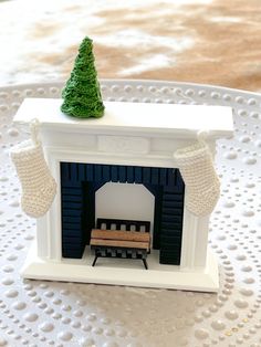 a miniature fireplace with a small christmas tree on top